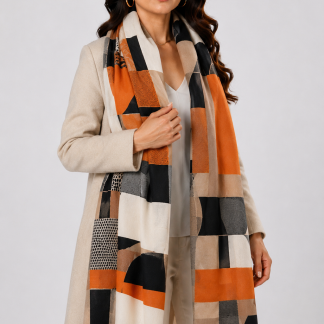 Mujer usando bufanda extra suave con diseño geométrico en tonos terracota, beige, negro y gris.
